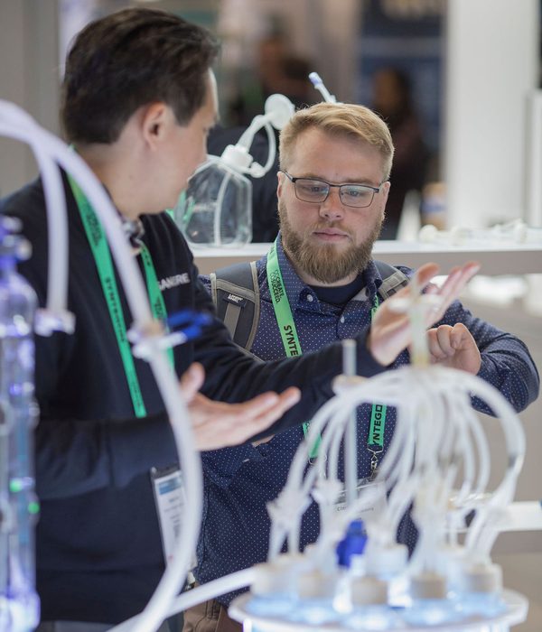 SaniSure team member and customer examining single-use tubing assembly and connectors at Interphex